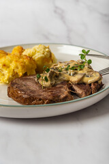 Eye fillet served with cauliflower gratin and mushroom sauce 
