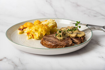Eye fillet served with cauliflower gratin and mushroom sauce 