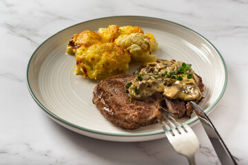 Eye fillet served with cauliflower gratin and mushroom sauce 