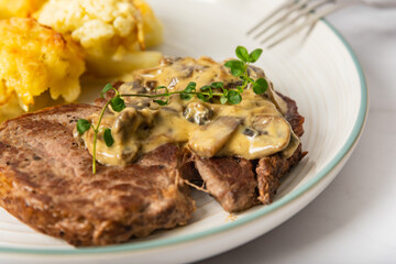 Eye fillet served with cauliflower gratin and mushroom sauce 