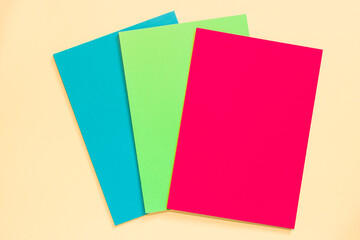 Empty sheets of colored paper on pink background. Children's creativity concept.