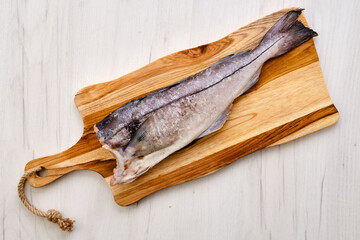 Top view of fresh haddock carcass on wooden cutting board