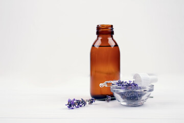 Mockup image of dropper bottle with lavender essential oil and lavender flowers on white background with copyspace for text. Trendy toned photo for your blog or presentation