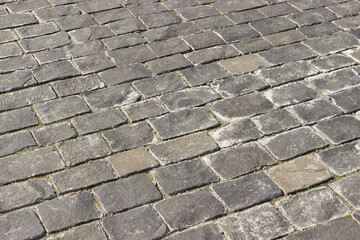 Cobbled stone road. Diagonal view. Paving stones on the street of the city.