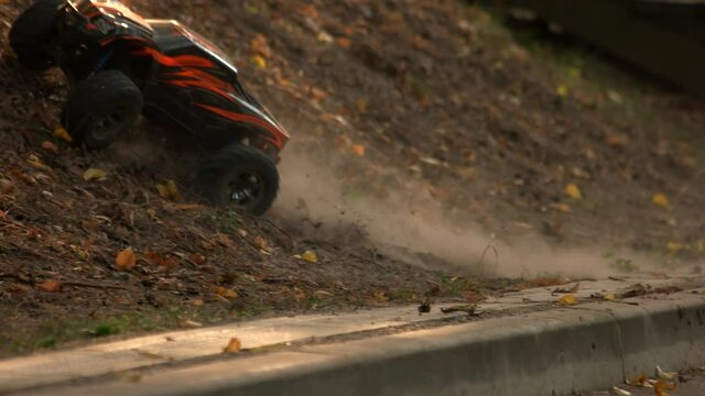 Remote control jeep car model climbing on the curb. RC car overrrides a road curb and keep going offroad.