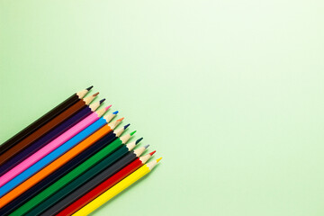 Set of color pencils on light blue background with copy space.