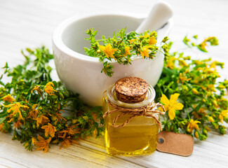 St johns wort oils, and  fresh herbs in a mortar
