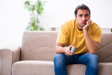 Obraz premium Young man watching tv at home