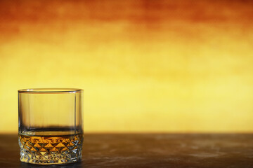A glass of hard alcohol with ice on a bar counter. Whiskey with soda in a glass. Advertising alcoholic drink.