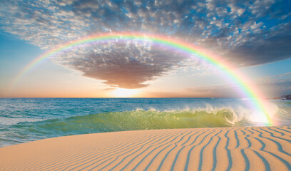 Rainbow falling into the power sea wave, sand dune in the foreground