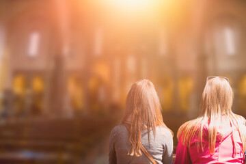 People praying in a church with sun rays