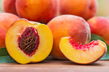 Fresh peaches on wooden table. Ripe peaches with leaves on a wooden board
