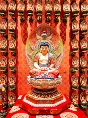 Buddhistic statues inside temple or shrine with buddhas and offerings and oblations in red and gold...