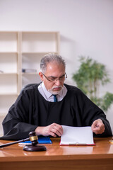 Fototapeta premium Old male judge working in courthouse