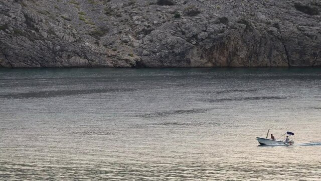 A small motorboat crosses the picture from right to left