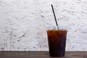 Iced Americano Coffee on the wood table.White texure background