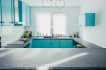 Blurred modern kitchen interior and desk space and outstanding turquoise furniture. 