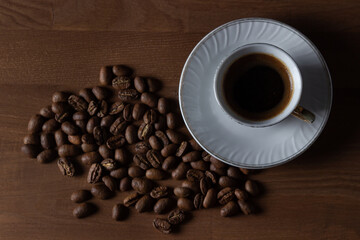 A cup of boiled coffee, coffee beans are next to it.