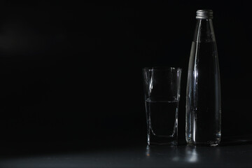 Close up pouring purified fresh drink water from the bottle on table in living room. Drinking water. Mineral vitamin water. Healthy, mineral-rich, refreshing water.