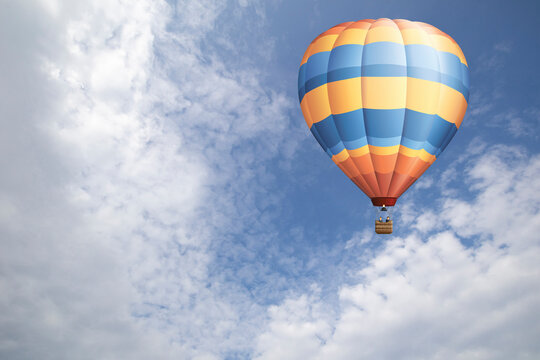 Hot air balloon set against a blue cloudy daytime sky