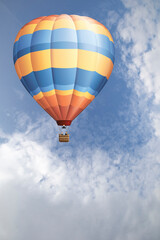 Hot air balloon set against a blue cloudy daytime sky
