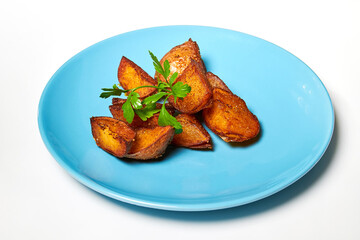 Peasant potatoes with spices and parsley on a blue plate. Idaho potatoes