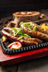 Grilled sausages with potatoes on the wooden table