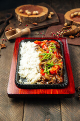 Beef with vegetables and rice in cast iron pan