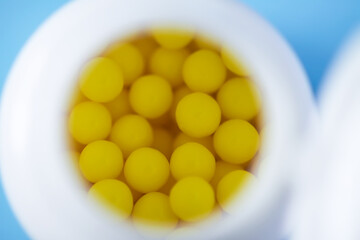 The plastic container of pills on bright blue background.