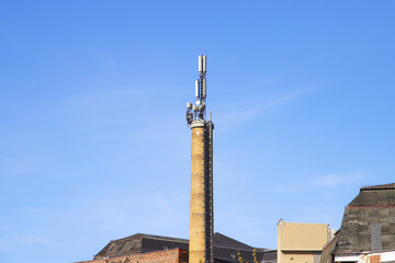 Fototapeta na wymiar Old brick chimney with cell phone antennas.
