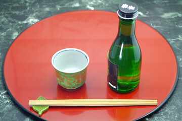 Sake cups and bottle on a lacquered tray