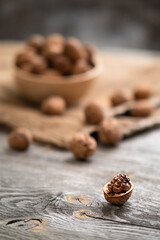 Fresh walnut kernels and whole walnuts in a bowl on rustic old wooden table. Healthy organic food, BIO viands, natural background. Copy space for your advertising text message