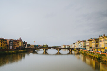 Rome, Italy - A panoramic view of the other side in front of Ponte Vecchio and the Arno river reflecting the buildings in its water during a cloudy afternoon.