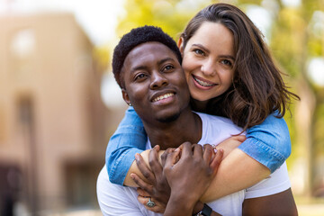 Affectionate multi-ethnic couple embracing outdoors

