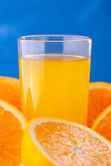 glass of fresh orange juice and orange fruit on a blue background. Health food.