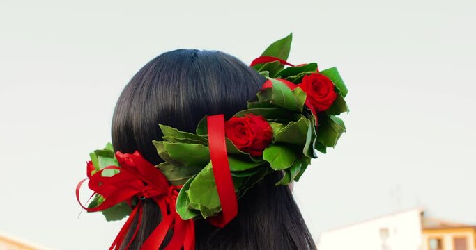 Giovane ragazza laureata con corona di alloro in testa sorride felice