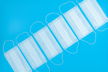 Medical hygienic mask, Face protective masks on blue background.Disposable surgical face mask protective against Coronovirus Covid-19,pollution, virus, flu.Healthcare medical surgical Flat lay pattern