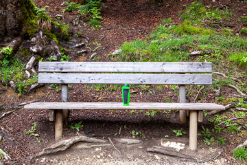 plastic water drinking bottle for sport activity on a wooden bench in public park. take a break