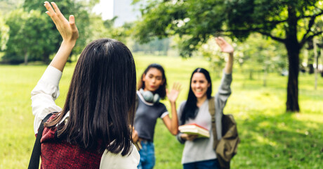 Woman student waving hello with her friend - friendship and togetherness concept