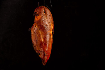 smoked chicken white meat in the process of smoking on a black background