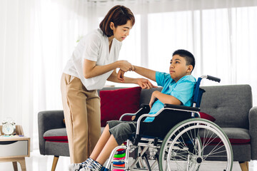 Fototapeta na wymiar Portrait of asian physiotherapist carer helping and playing with special disabled child health problem by doing exercises sitting in wheelchair in rehabilitation clinic.disability care concept