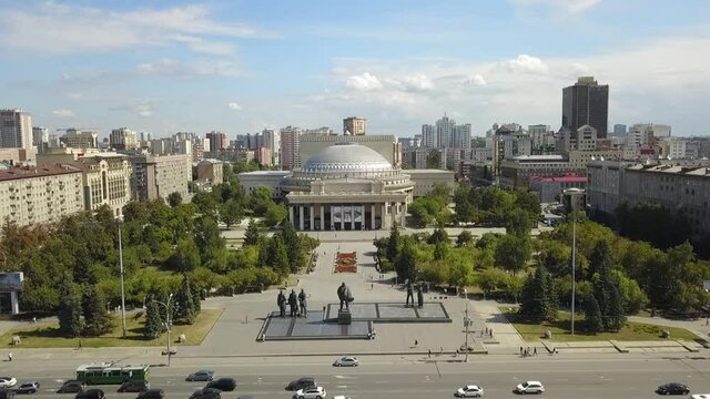 The flying camera shows the main attractions of Novosibirsk with a view of the city from and road traffic.