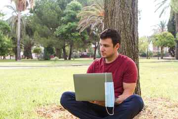 adult working telecommuting with laptop in the park. freelancer