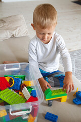 Child playing with toy blocks sitting on sofa