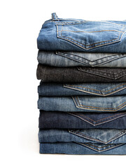 Lot of various used unisex jeans stacked in a pile isolated on white