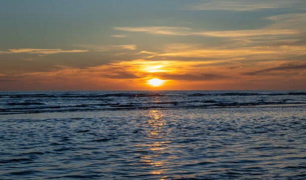 Zachód słońca na plaży w Egmond aan Zee, Holandia Północna.