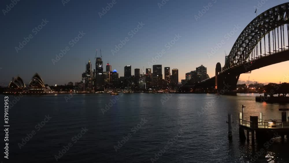 Poster dark timelapse of city of sydney cbd waterfront across harbour & bridge–4k.