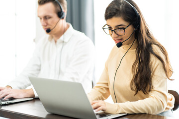 Beautiful female call center operator working on computer in office. Communication support for callcenter and customer service Helpdesk