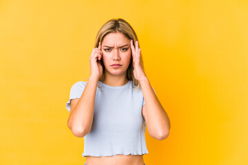 Naklejka premium Young blonde caucasian woman isolated focused on a task, keeping forefingers pointing head.