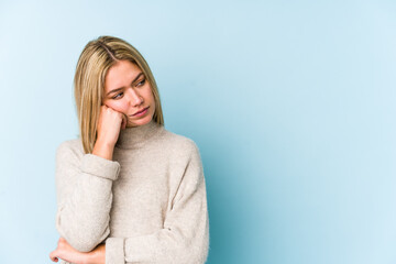 Young blonde caucasian woman isolated who feels sad and pensive, looking at copy space.